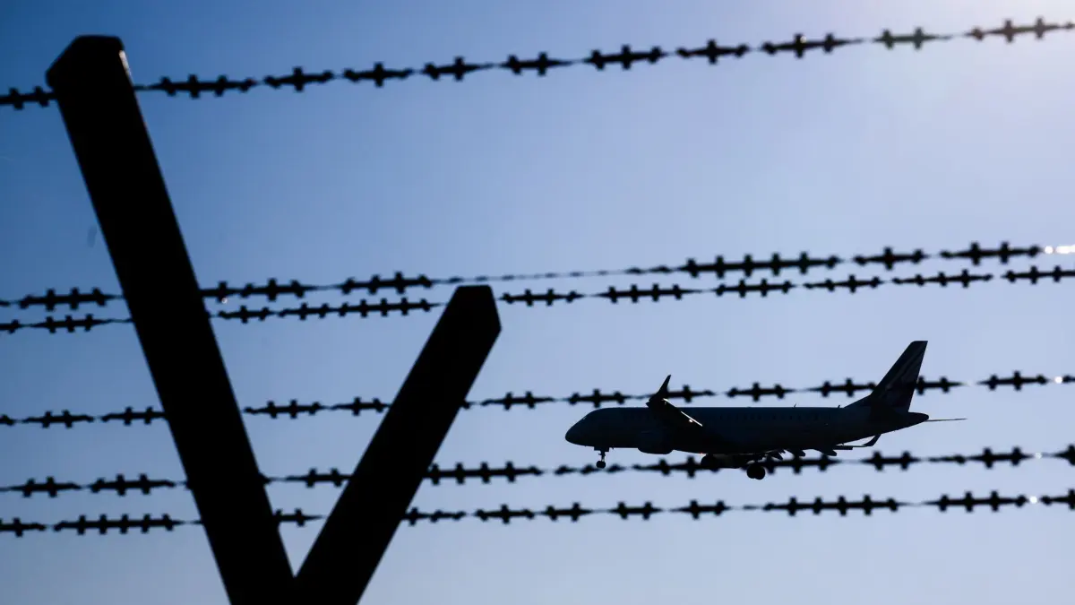 Symbolbild Abschiebung: ARCHIV - 17.02.2025, Niedersachsen, Langenhagen: Ein Flugzeug fliegt hinter Stacheldraht am Flughafen Hannover. (zu dpa: «EU einig: Weg für Abschiebezentren in Drittstaaten frei») Foto: Julian Stratenschulte/dpa +++ dpa-Bildfunk +++