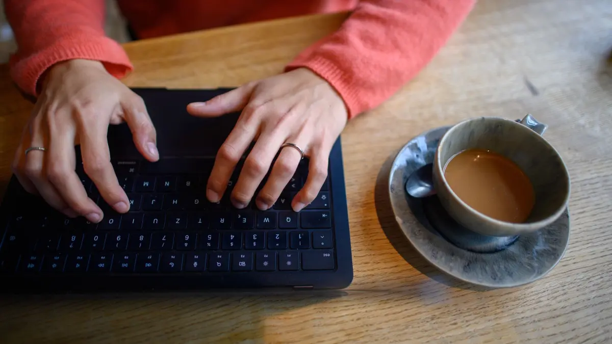Eine Frau nutzt ihren Laptop in einem Café: ARCHIV - «Nur kurz die IBAN eingeben» klingt harmlos – kann aber teuer werden. Das Amtsgericht Bernau sagt: Das ist nicht automatisch ein versicherter Phishing-Fall in der Hausratpolice. (zu dpa: «IBAN in Chat verraten: Hausrat mit Cyber-Schutz zahlt nicht») Foto: Klaus-Dietmar Gabbert/dpa/dpa-tmn - Honorarfrei nur für Bezieher des dpa-Themendienstes +++ dpa-Themendienst +++