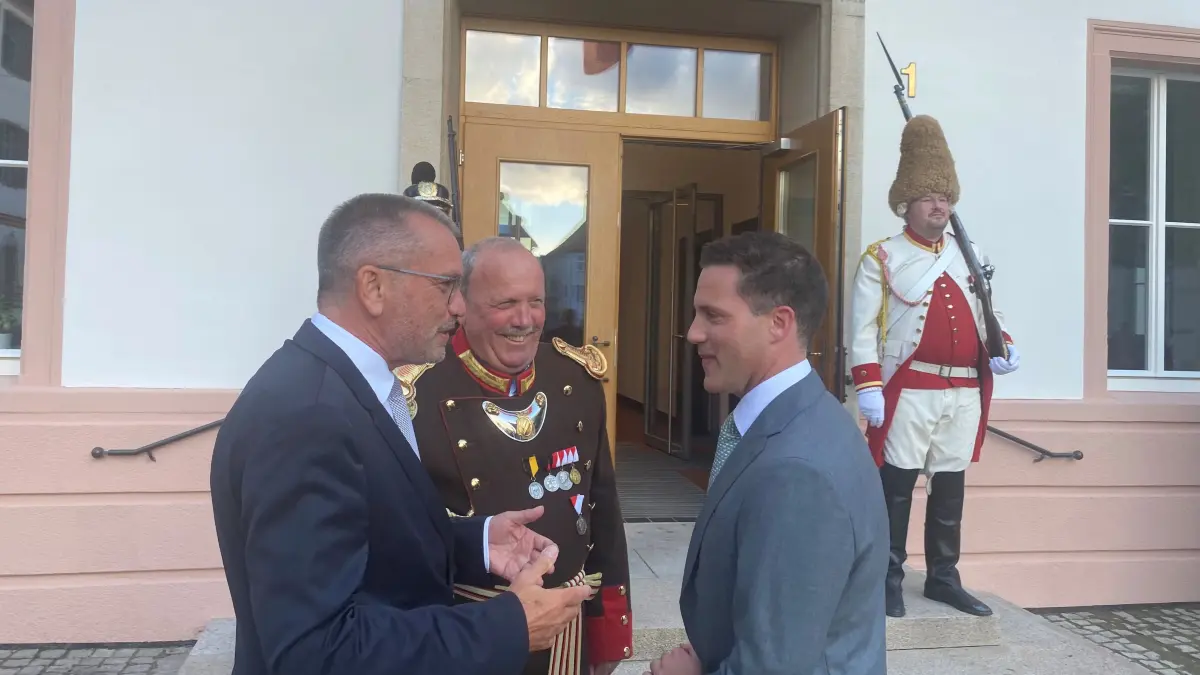 Innenminister Manuel Hagel wird am Mittwochabend in seiner Heimatstadt von Oberbürgermeister Alexander Baumann (l.) und Josef Stocker begrüßt. Stocker ist Kommandant der Historischen Bürgerwache der Stadt, die kurz darauf den Großen Zapfenstreich auf dem Marktplatz abhielt.