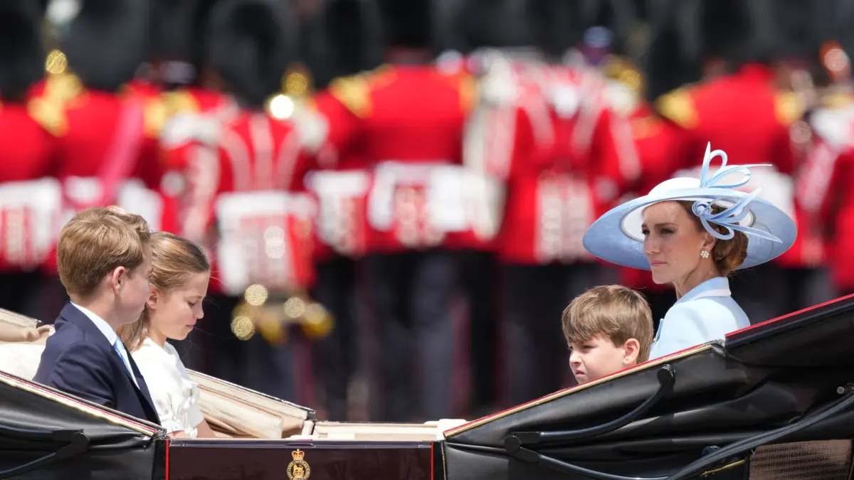 Trooping the Colour in London: 13.06.2026, Großbritannien, London: Kate, Prinzessin von Wales (r), fährt zusammen mit ihren Kindern Prinz Louis, Prinzessin Charlotte und Prinz George (2.v.r) in einer offenen Kutsche zurück zum Buckingham Palace während der «Trooping the Colour», der jährlichen Geburtstagsparade des Königs. Foto: Kirsty Wigglesworth/AP/dpa +++ dpa-Bildfunk +++