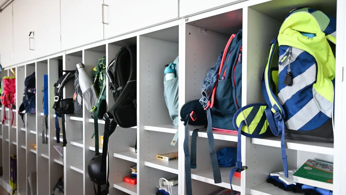 Grundschule: SYMBOLBILD - 05.11.2025, Baden-Württemberg, Stuttgart: Schulranzen und verschiedene Unterrichtsmaterialien liegen in offenen Regalfächern eines Garderobenbereichs einer vierten Klasse in einer Grundschule. In den Fächern sind unter anderem Hefte, Bücher, Turnbeutel und persönliche Gegenstände der Kinder verstaut. (zu dpa: «Weniger Kinder, viele Baustellen – Bildung bleibt Krisenfall») Foto: Bernd Weißbrod/dpa +++ dpa-Bildfunk +++