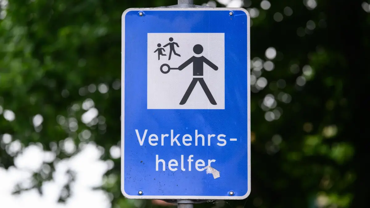 93-jähriger Schulweghelfer in Dresden: PRODUKTION - 11.06.2026, Sachsen, Dresden: Ein Schild „Verkehrshelfer“, fotografiert im Rahmen eines Presssetermins mit Werner Niehle, dem 93-jährigen Schulweghelfer, vor einer Schule. Mit 93 Jahren sorgt Werner Niehle aus Dresden noch immer jeden Morgen dafür, dass Kinder sicher zur Schule kommen. Damit gilt er als wohl ältester Schulweghelfer Deutschlands. Bei Wind und Wetter hilft er täglich mehr als 300 Schülerinnen und Schülern über die Straße. Für Werner ist die Aufgabe mehr als ein Ehrenamt. (zu dpa: «Mit 93 Jahren sorgt Werner Niehle für sichere Schulwege») Foto: Robert Michael/dpa +++ dpa-Bildfunk +++