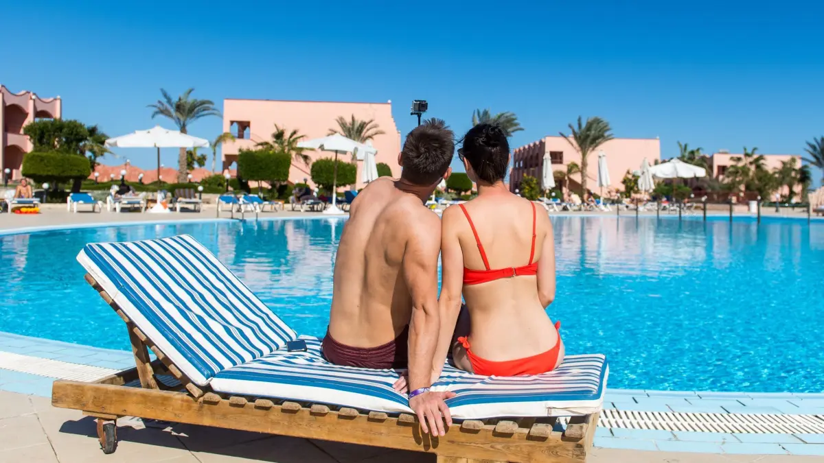 Selfies am Hotelpool: ILLUSTRATION - Ab ins Warme: Viele buchen ihren Sommerurlaub kurzfristig. (zu dpa: «Last-Minute in den Sommerurlaub: Was Urlauber wissen müssen») Foto: Benjamin Nolte/dpa-tmn - Honorarfrei nur für Bezieher des dpa-Themendienstes +++ dpa-Themendienst +++