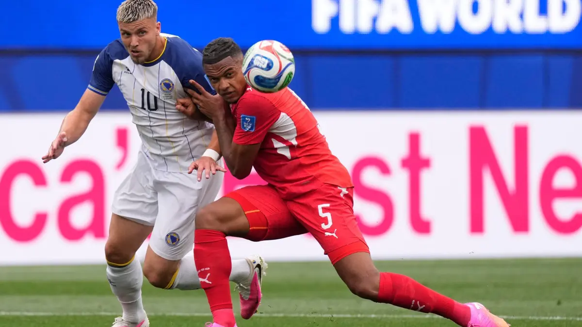 WM 2026 - Schweiz - Bosnien-Herzegowina: 18.06.2026, USA, Inglewood: Fußball, Männer, WM, Schweiz - Bosnien-Herzegowina, Vorrunde, Gruppe B, 2. Spieltag, Los-Angeles-Stadion. Bosniens Ermedin Demirovic (l) und der Schweizer Manuel Akanji kämpfen um den Ball. Foto: Mark J. Terrill/AP/dpa +++ dpa-Bildfunk +++