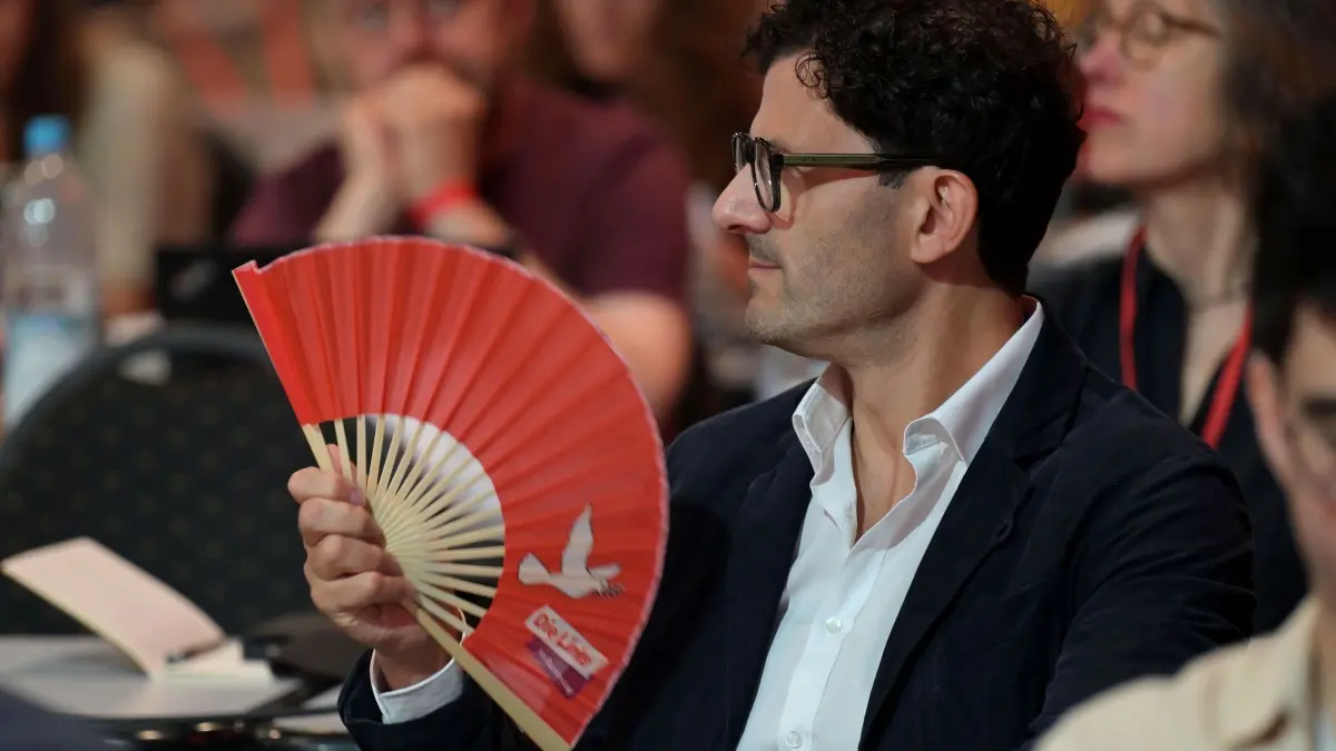 10. Bundesparteitag der Linken: 20.06.2026, Brandenburg, Potsdam: Luigi Pantisano, Bundestagsabgeordneter Die Linke, fächelt sich Luft mit einem Fächer beim Bundesparteitag der Linken in der Metropolis Halle in Potsdam zu.
Schwerpunkte des dreitägigen Parteitages sind die Wahl des Parteivorstandes und die inhaltliche politisch aktuelle Debatte. Foto: Michael Bahlo/dpa +++ dpa-Bildfunk +++