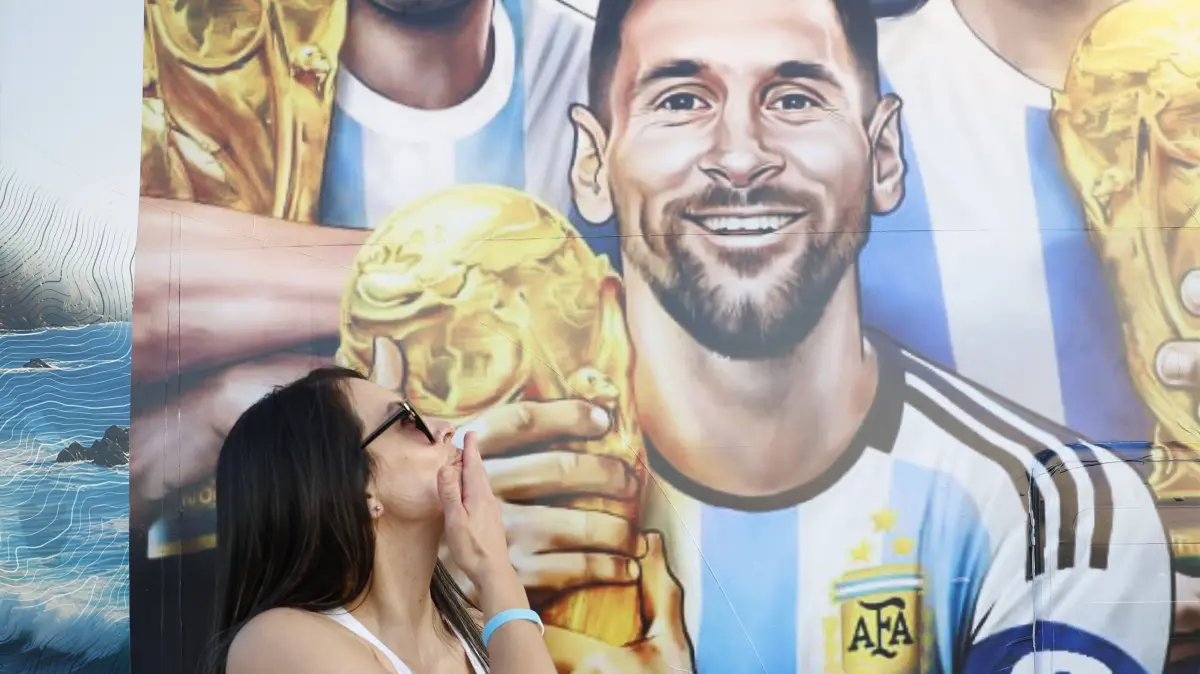 A fan of Argentina pose next a poster with an image of Lionel Messi in Euless, Texas, USA, 20 June 2026. Argentina will face Austria in a Group J match of the FIFA World Cup, WM, Weltmeisterschaft, Fussball 2026 on Monday. FIFA World Cup 2026 - Fans of Argentina in Texas ACHTUNG: NUR REDAKTIONELLE NUTZUNG PUBLICATIONxINxGERxSUIxAUTxONLY Copyright: xMariscalx GR7089 20260621-55020661395_1