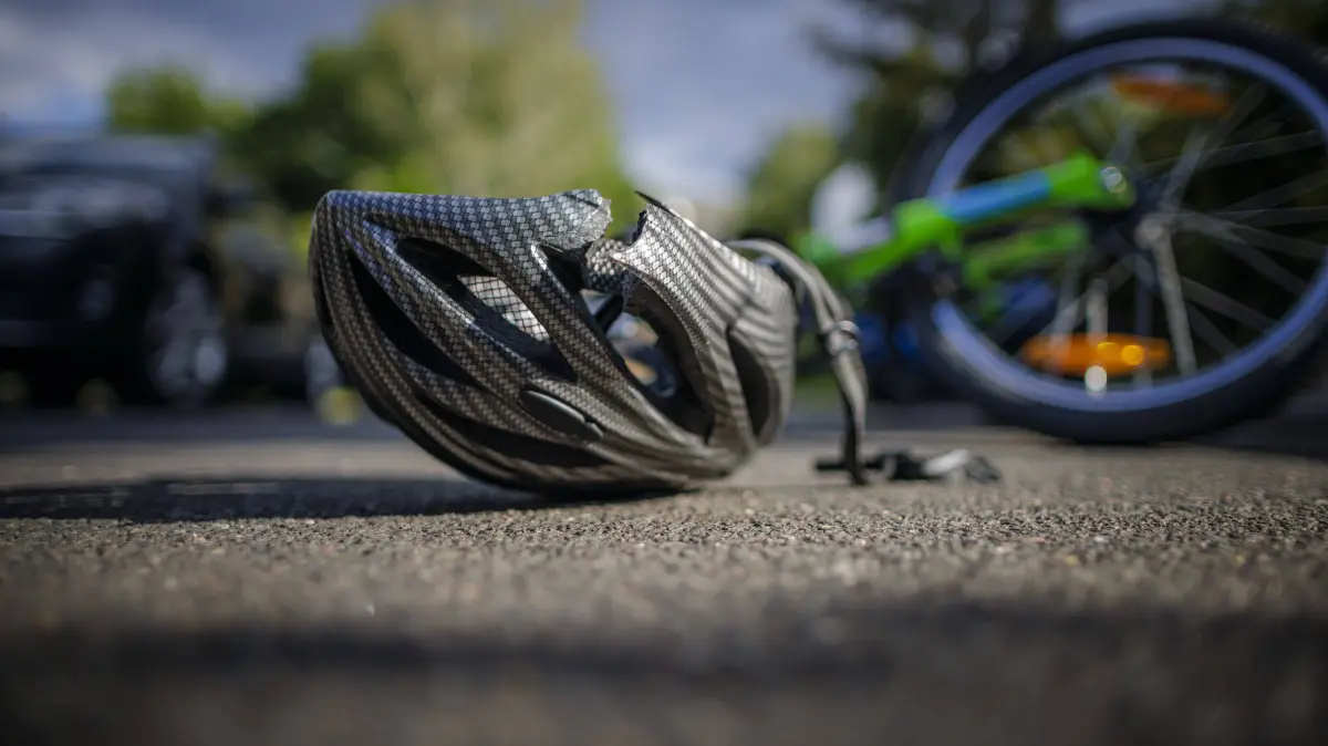 Symbolfoto zum Thema Fahrradunfall gestellte Szene. Ein zerbrochener Fahrradhelm liegt neben einem Fahrrad auf einer Strasse. Berlin, 21.08.2024. Berlin Deutschland *** Symbol photo on the topic Bicycle accident posed scene A broken bicycle helmet lies next to a bicycle on a street Berlin, 21 08 2024 Berlin Germany Copyright: xThomasxTrutschel/photothek.dex