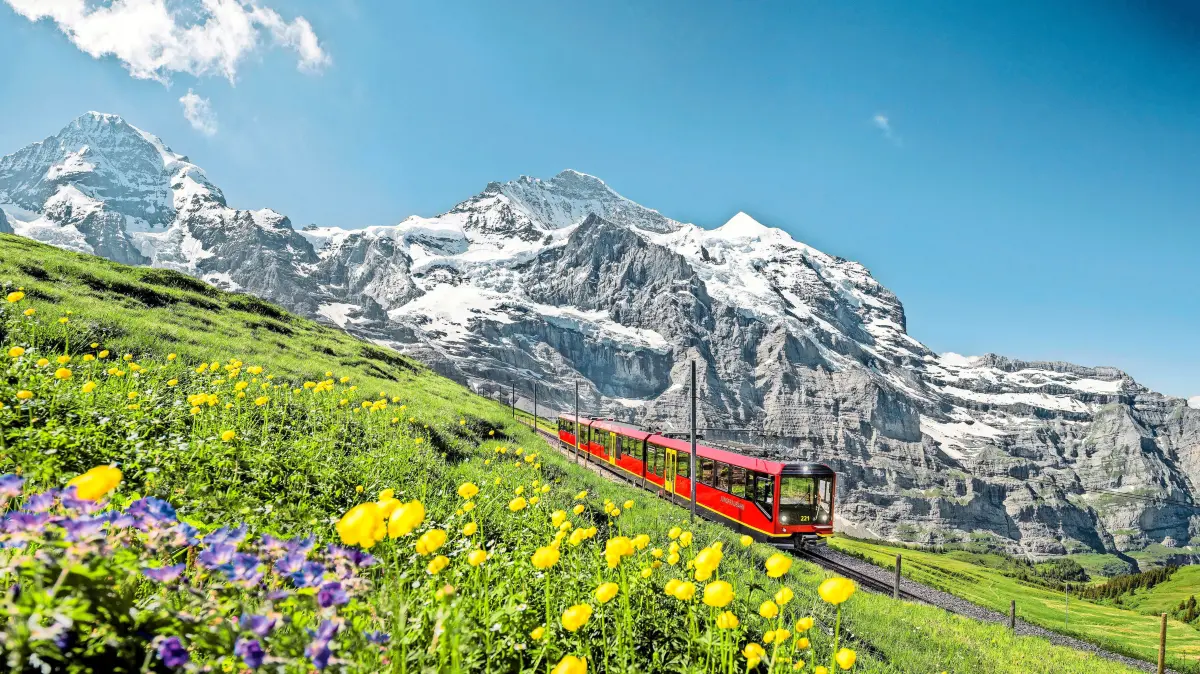 Jungfraubahn im Sommer mit dem Dreigestirn im Hintergrund.