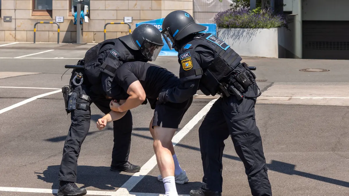 14. Landestag der Verkehrssicherheit, Nürnberg, 27.06.2026: 14. Landestag der Verkehrssicherheit, Nürnberg, 27.06.2026 Zwei Beamte des Unterstützungskommandos USK der Polizei demonstrieren in Schutzausrüstung und Helm die Fixierung einer Person. Die Szene ist eine Vorführung - kein echter Einsatz. Nürnberg Bayern Deutschland *** 14th State Road Safety Day, Nuremberg, June 27, 2026 Two officers from the polices USK Support Unit, wearing protective gear and helmets, demonstrate how to restrain a person. The scene is a demonstration, not an actual operation. Nuremberg, Bavaria, Germany 20260627-286A0443-M4000