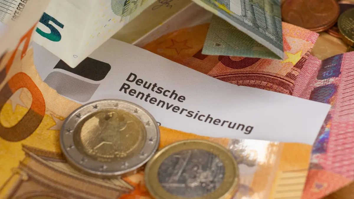 Verdi und Sozialverband enttäuscht über Renten-Vorschläge: ILLUSTRATION - 26.11.2025, Berlin: Ein Schreiben der Deutschen Rentenversicherung liegt zwischen Euro-Banknoten und mehreren Euromünzen. (zu dpa: «Rentenreform soll kommen - Offene Frage zu Minijobs») Foto: Fernando Gutierrez-Juarez/dpa +++ dpa-Bildfunk +++