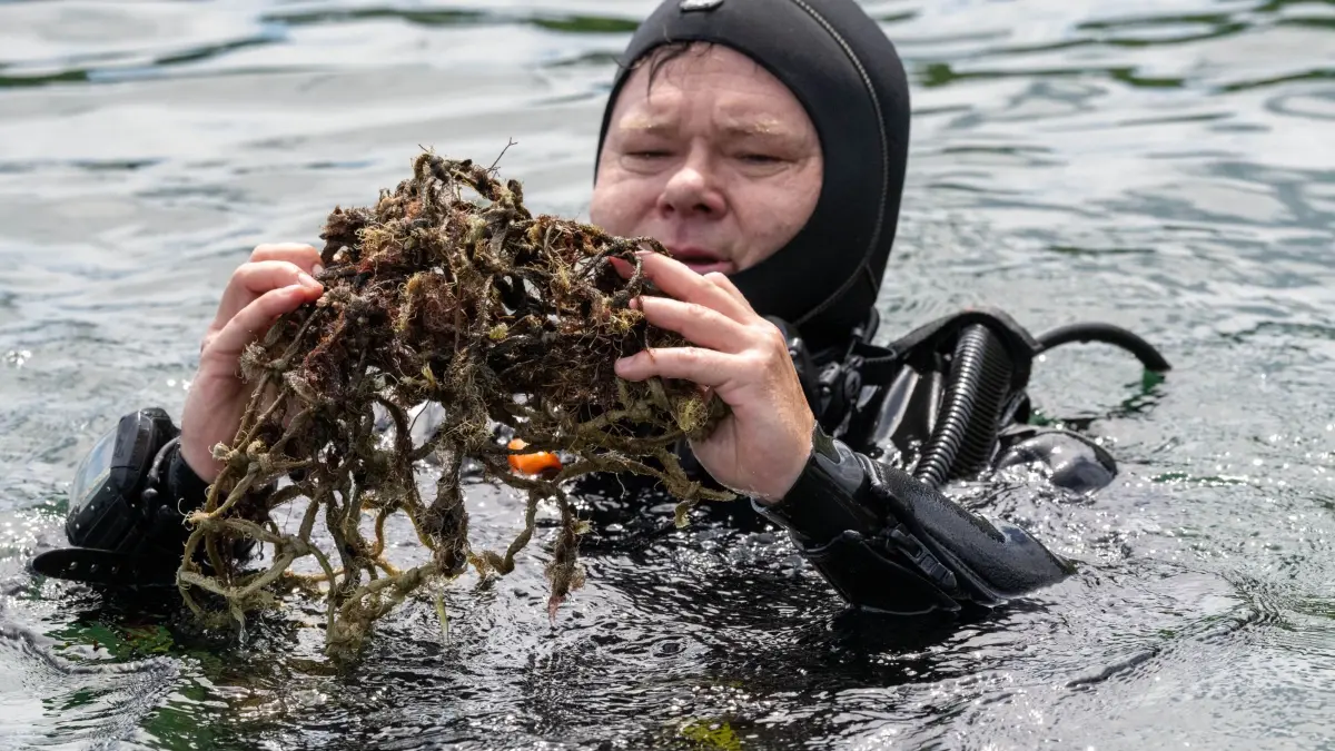 Fortsetzung der Sommerreise von Bundesumweltminister: 02.07.2026, Mecklenburg-Vorpommern, Sassnitz: Carsten Schneider (SPD), Bundesminister für Umwelt, Klimaschutz, Naturschutz und nukleare Sicherheit, hält in der Ostsee ein sogenanntes Geisternetz. Foto: Stefan Sauer/dpa +++ dpa-Bildfunk +++