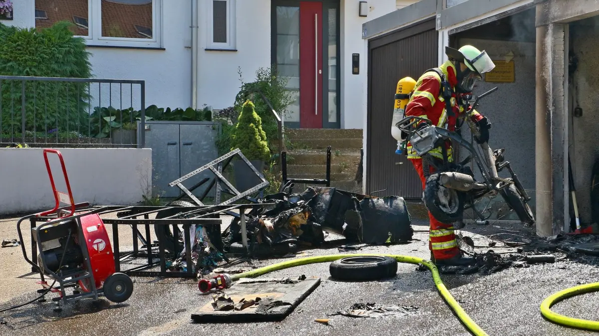 02.07.2026: Während am Donnerstagmittag bereits eine Vielzahl von Einsatzkräften der Leonberger Feuerwehr bei einem Gefahrgutunfall auf der A8 im Einsatz waren, meldeten Anrufer gegen 14 Uhr den Brand mehrerer Garagen im Ortsteil Höfingen. Die ILS Böblingen alarmierte daraufhin die Abteilungen Leonberg-Innenstadt, Höfingen und Gebersheim. Eine weithin sichtbare Rauchwolke wies den anfahrenden Kräften den Weg. Beim Eintreffen brannte eine Garage in einer Garagenanlage in voller Ausdehnung. Umgehend wurden zwei Rohre zur Brandbekämpfung vorgenommen. Mit einer Wärmebildkamera wurde kontrolliert ob sich das Feuer in das Dach bzw. die angrenzenden Garagen durchgefressen hatte. Nachdem der Brand gelöscht war, wurde im Rahmen der Nachlöscharbeiten die Garage ausgeräumt und mit dem Hochleistungslüfter entraucht.
Foto: KS-Images.de/Andreas Rometsch