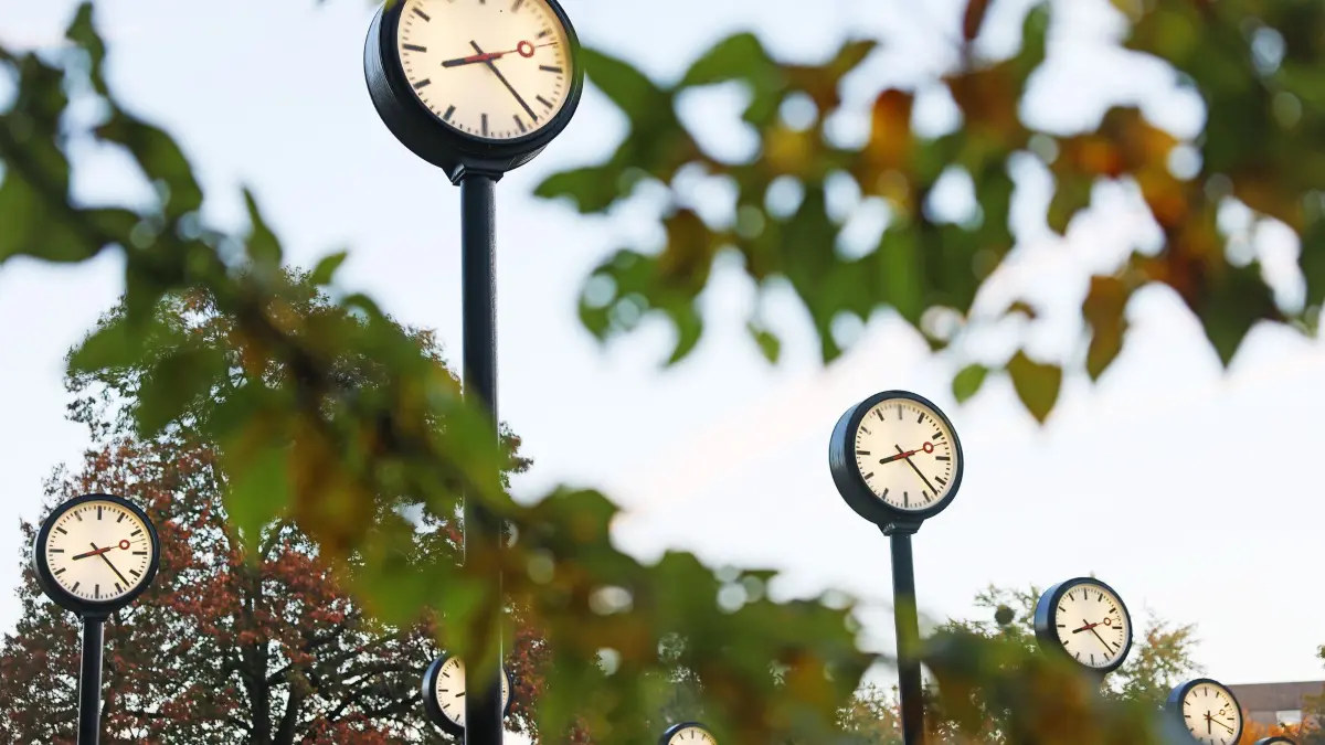 Uhrenpark - Zeitumstellung: ARCHIV - 25.10.2021, Nordrhein-Westfalen, Düsseldorf: Uhren leuchten am Morgen im Zeitfeld im Volksgarten. Die Zeitumstellung von Sommer- auf Winterzeit ist in der Nacht zum 31.10.2021. (zu dpa: «Achtung «Nervenprobe»: Hohe Staugefahr zum Ferienstart») Foto: Oliver Berg/dpa +++ dpa-Bildfunk +++