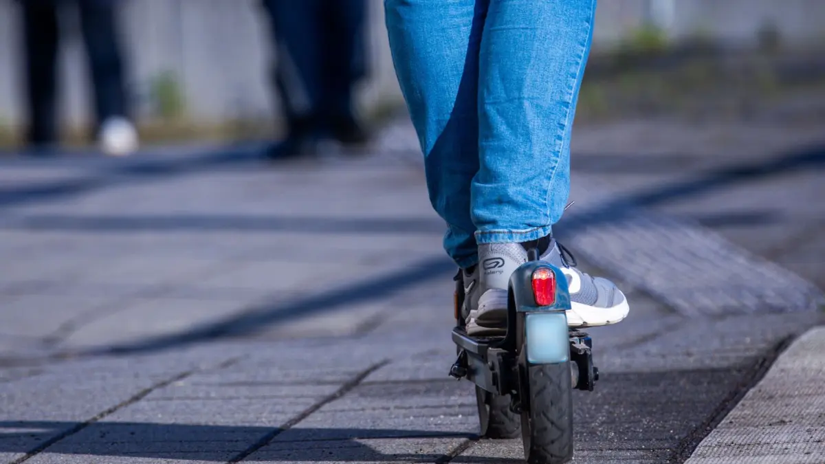 E-Scooter: ARCHIV - 17.04.2024, Mecklenburg-Vorpommern, Wismar: Ein Reisender fährt mit seinem E-Scooter über den Bahnsteig. (zu dpa: «14-Jähriger bei Unfall mit E-Scooter schwer verletzt») Foto: Jens Büttner/dpa +++ dpa-Bildfunk +++