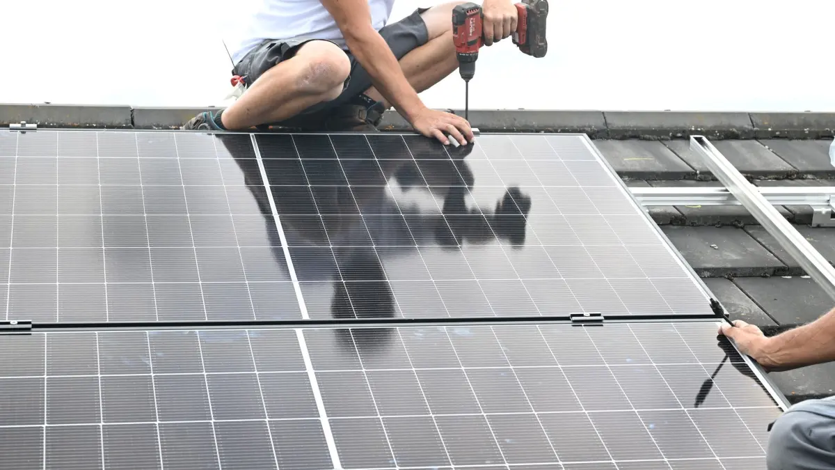 Installation einer PV Anlage: PRODUKTION - 06.07.2026, Baden-Württemberg, Steinheim: Auf einem Dach eines Privathauses wird eine PV Anlage zur Stromerzeugung installiert. (zu dpa: «Ökostrom vom eigenen Dach: Reiche mildert Einschnitte ab») Foto: Bernd Weißbrod/dpa +++ dpa-Bildfunk +++