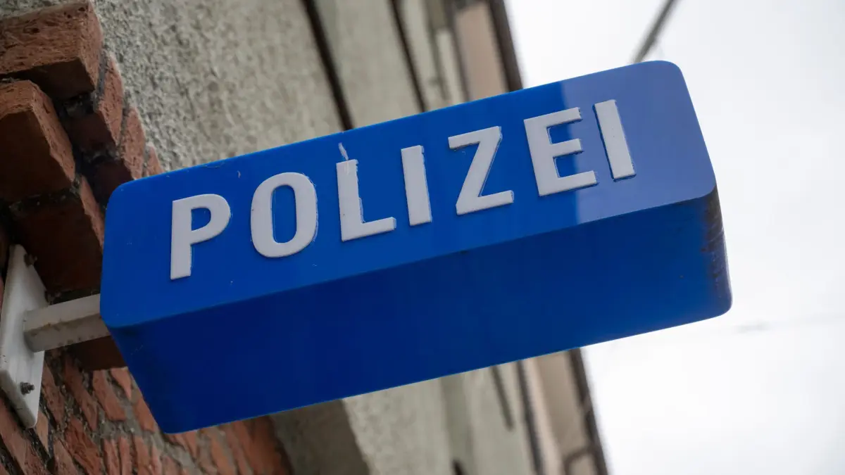Polizei: ARCHIV - 22.11.2023, Bayern, München: Ein Schild hängt am Eingang zu einer Polizeiinspektion. (zu dpa: «Vermisster tot in Bachbett gefunden») Foto: Peter Kneffel/dpa +++ dpa-Bildfunk +++