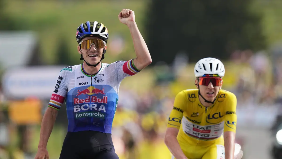 Radsport: Tour de France: 19.07.2026, Frankreich, Brison: Radsport: UCI WorldTour - Tour de France, Champagnole - Plateau de Solaison (183,90 km), 15. Etappe. Remco Evenepoel (l) aus Belgien jubelt über seinen Etappensieg neben Tadej Pogacar aus Slowenien. Foto: Thibault Camus/AP/dpa +++ dpa-Bildfunk +++