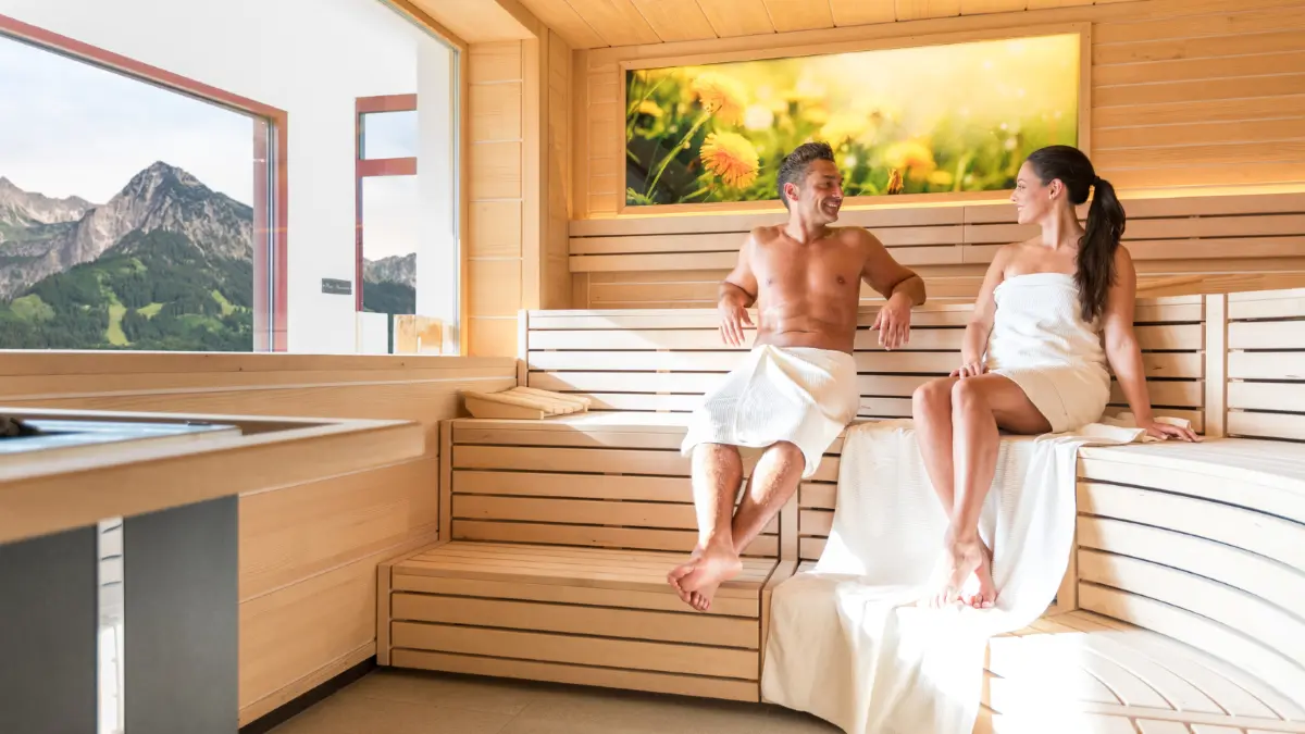 Wellness im Tanneck bedeutet warmes Wasser, Saunen, Dachlounge und Milchwell®-Anwendungen mit weitem Blick über das Allgäu.