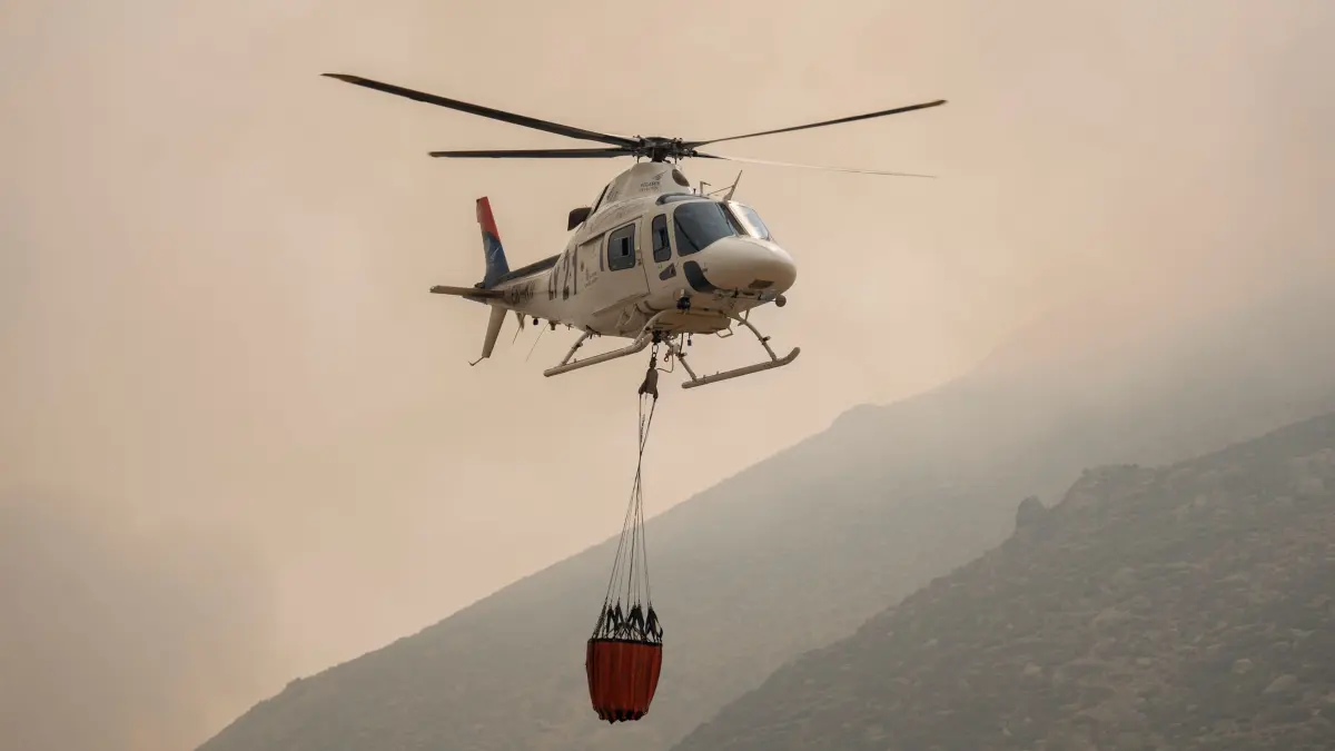Brände in Spanien: 27.07.2026, Spanien, Mijares: Ein Hubschrauber unterstützt die Löscharbeiten. Der Waldbrand in Burgohondo (Ávila) hat 55.000 Hektar verwüstet und ist damit der größte jemals in Spanien verzeichnete Brand. Derzeit konzentrieren sich die Löscharbeiten auf zwei aktive Brandherde, die den Einsatzkräften besondere Sorge bereiten, den Mijares-Pass und das Gebiet um die Ortschaft Casillas. Foto: Alberto Ortega/EUROPA PRESS/dpa +++ dpa-Bildfunk +++