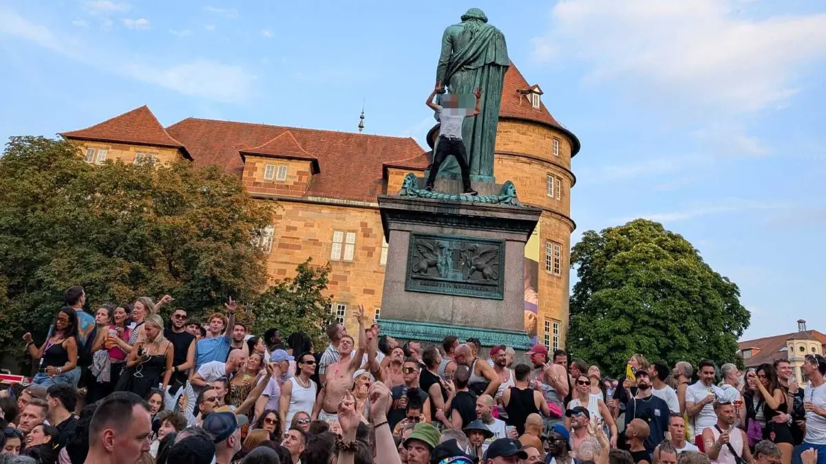 Mann kletter auf Schillerdenkmal