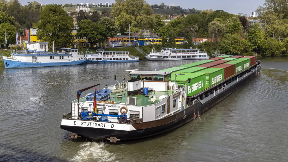 Containerschiff unterwegs auf dem Neckar, im Hintergrund die Anlegestelle Wilhelma, Ausflugsschiffe am Neckar. // 24.04.2024: Stuttgart, Baden-Württemberg, Deutschland *** Container ship underway on the Neckar, in the background the Wilhelma landing stage, excursion boats on the Neckar 24 04 2024 Stuttgart, Baden Württemberg, Germany