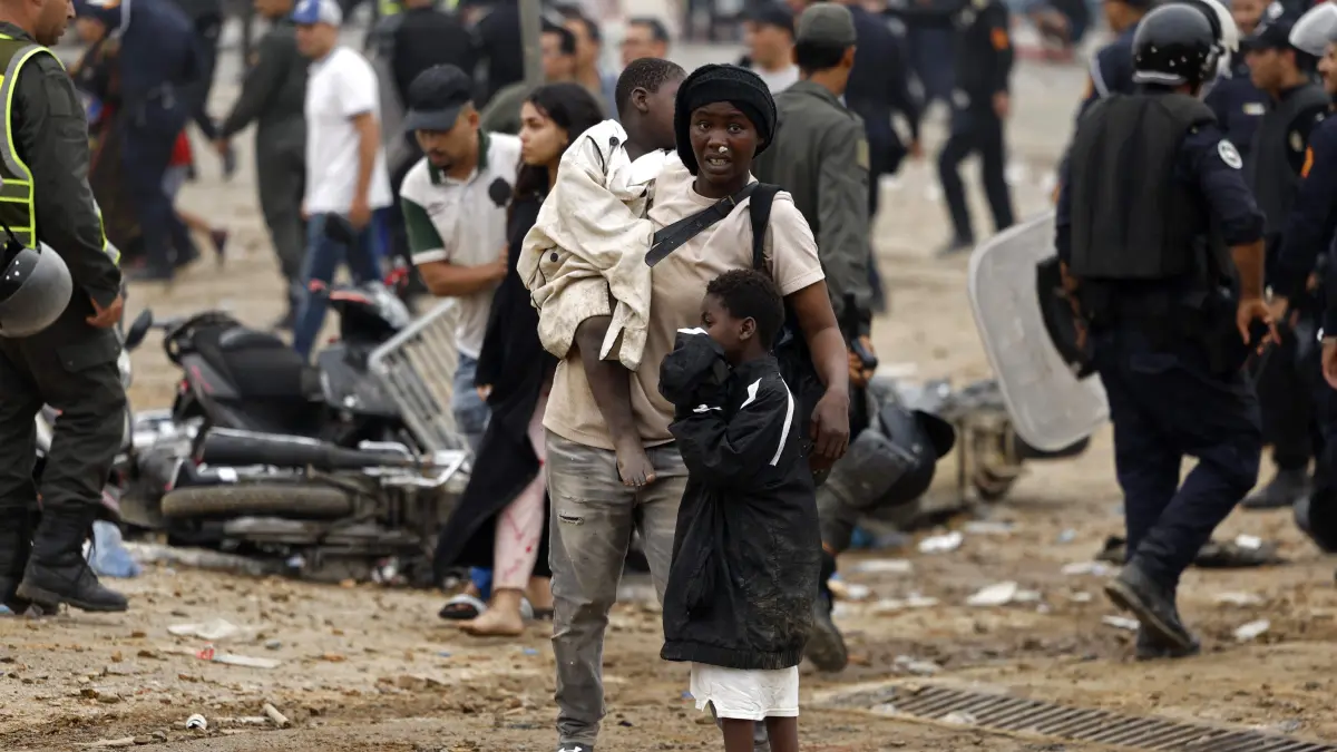 MOROCCO-SPAIN-MIGRATION: People react as they stand at the site of clashes near Fnideq, on the Morocco-Spain border, on July 31, 2026. Thousands of migrants crossed overnight from Morocco into Spain's north Africa's Ceuta enclave, a police source said on July 31, adding that it was impossible to estimate how many people in total. A total of 18 people died while attempting to reach the Spanish enclave, the source said. (Photo by Abdel Majid BZIOUAT / AFP)