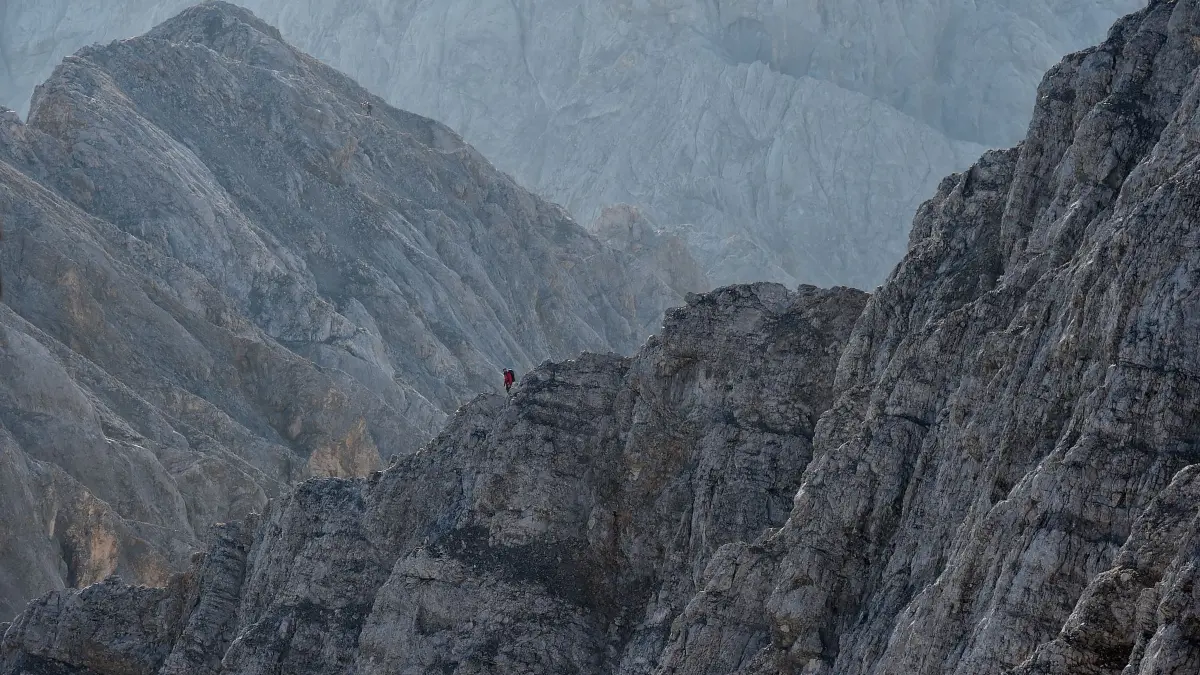 Jubiläumsgrat nahe der Zugspitze: ARCHIV - 05.09.2018, Bayern, Grainau: Ein Bergsteiger begeht beim Sonnenaufgang den Jubiläumsgrat. (zu dpa: «Nahe Zugspitze: 68-jähriger Bergsteiger tödlich abgestürzt») Foto: Angelika Warmuth/dpa +++ dpa-Bildfunk +++