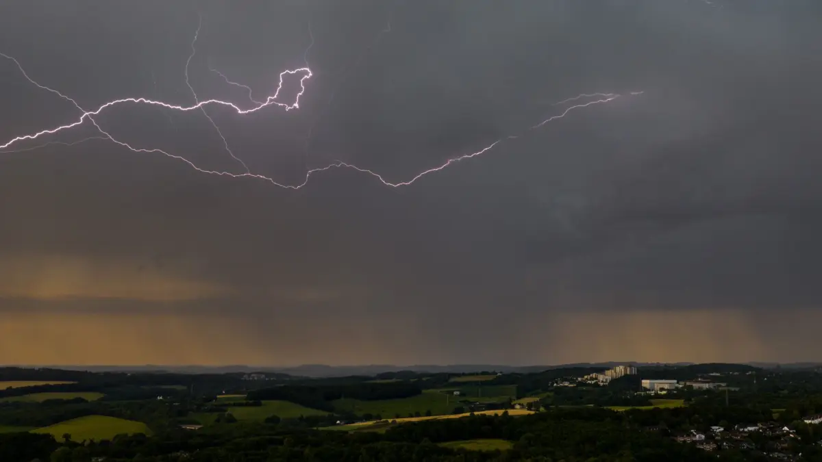 Wetter in NRW: ARCHIV - 19.06.2026, Nordrhein-Westfalen, Wuppertal: Blitze leuchten am Himmel über Wuppertal (Aufnahme mit einer Drohne). (zu dpa: «Es wird etwas weniger heiß – ab Nachmittag Gewitter möglich») Foto: Christoph Reichwein/dpa +++ dpa-Bildfunk +++