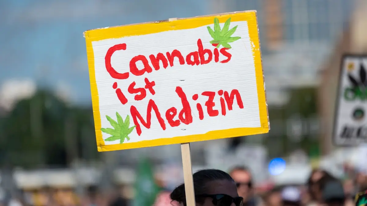 Hanfparade 2026: 08.08.2026, Berlin: Ein Teilnehmer der Hanfparade 2026 unter dem Motto "Gerecht! Gesund! Genießen!" trägt ein Plakat mit der Aufschrift Cannabis ist Medizin. Foto: Christophe Gateau/dpa +++ dpa-Bildfunk +++