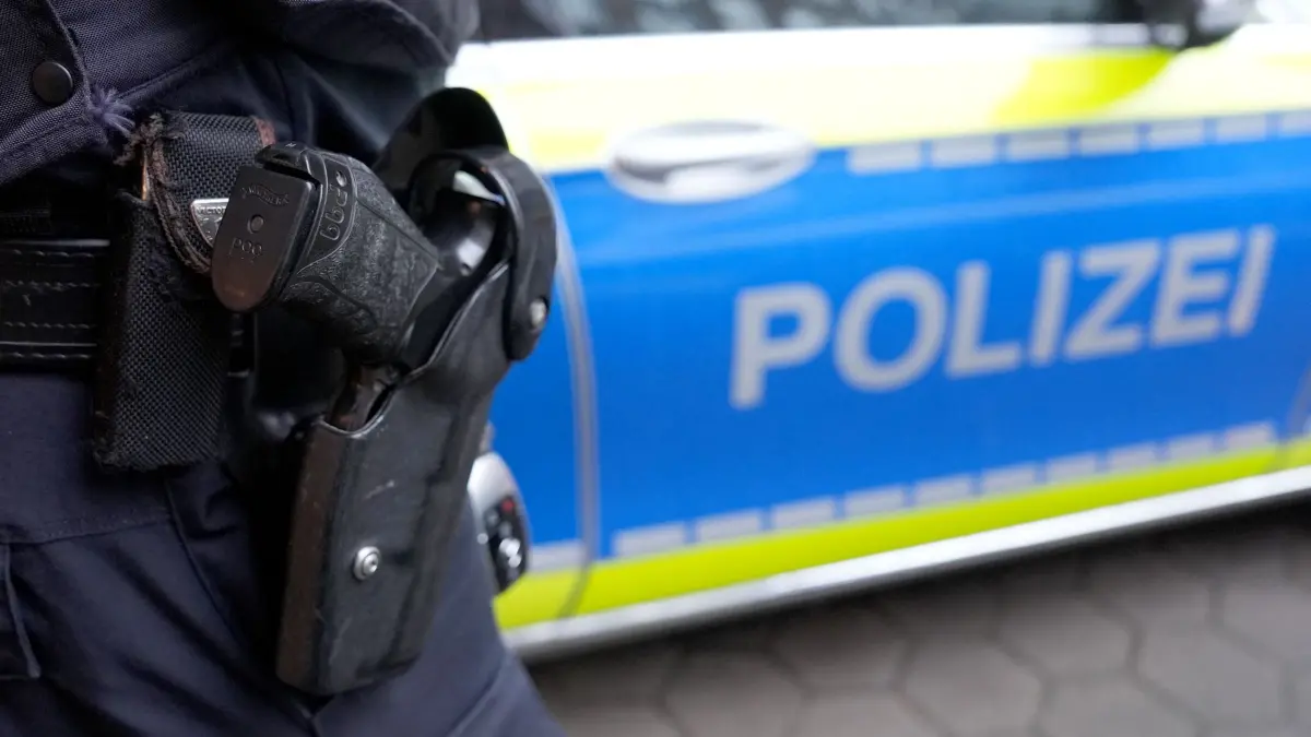 Polizeieinsatz: ARCHIV - 15.03.2024, Hamburg: Ein Polizist steht vor einem Einsatzfahrzeug der Polizei. (zu dpa: «Gefahrenbremsung eines Linienbusses - mehrere Verletzte») Foto: Marcus Brandt/dpa +++ dpa-Bildfunk +++