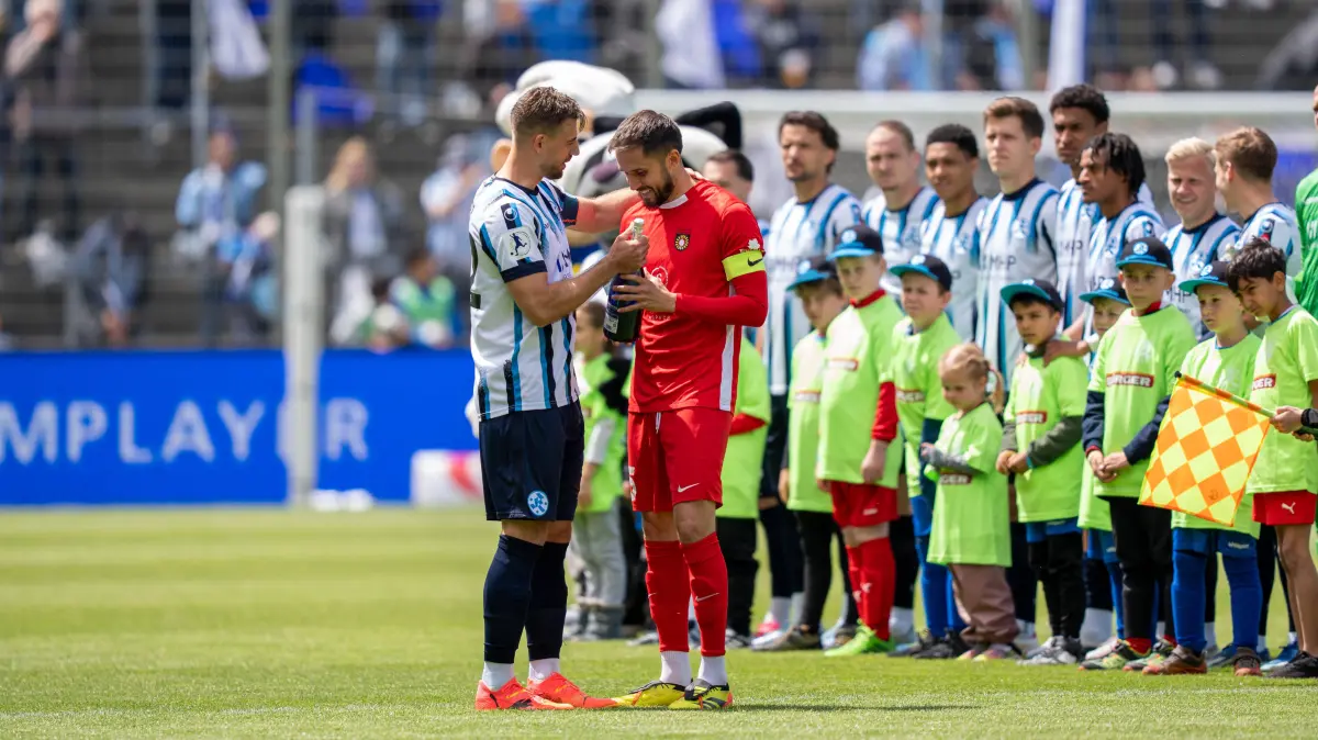 David Braig Stuttgarter Kickers, 22 uebergibt ein Geschenk an Volkan Celiktas SG Sonnenhof Großaspach, 05 zur Meisterschaft und dem Aufstieg, Stuttgarter Kickers vs. SG Sonnenhof Großaspach, Fussball, Regionalliga Suedwest, 34. Spieltag, 16.05.2026 Stuttgart-Degerloch Baden-Wuerttemberg Deutschland *** David Braig Stuttgarter Kickers, 22 hands over a present to Volkan Celiktas SG Sonnenhof Großaspach, 05 for the championship and promotion, Stuttgarter Kickers vs SG Sonnenhof Großaspach, Soccer, Regionalliga Suedwest, 34 Matchday, 16 05 2026 Stuttgart Degerloch Baden Wuerttemberg Germany Copyright: xkolbert-press/PhilipxZieglerx