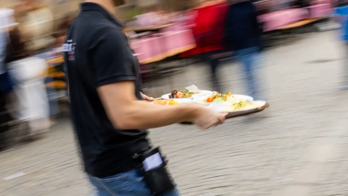 Rundgang über das 50. Stuttgarter Weindorf: Stuttgart, Baden-Württemberg, 22.08.2026:
Rundgang über das 50. Stuttgarter Weindorf auf dem Marktplatz und Schillerplatz
Im Bild: Ein Kellner trägt ein Tablett mit Essen
Notiz: No model release. Kein Einverständnis für Werbung, keine Weitergabe an Dritte.