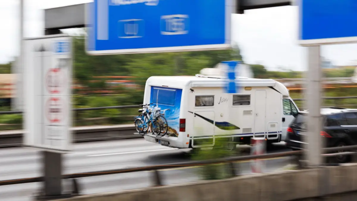 Rückreiseverkehr zum Ende der Sommerferien in Berlin: 23.08.2026, Berlin: Autofahrer fahren auf der Autobahn 100 nahe des Berliner Autobahndreiecks Funkturm. Die Halenseestraße Ost ist dort von Samstag, 20 Uhr, bis Sonntag, 22 Uhr nicht befahrbar. Die Straße ist in Richtung Messedamm ab dem Rathenauplatz gesperrt. Grund ist der Aufbau eines Traggerüsts für den Neubau der Ringbahnbrücke auf der A100. Foto: Carsten Koall/dpa +++ dpa-Bildfunk +++