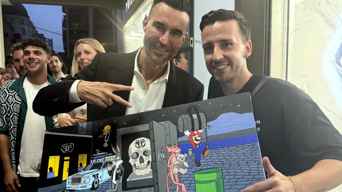 Philipp Plein (li.) nimmt in Monaco vom Stuttgarter Sven Micklitz dessen Gemälde entgegen, welches er für ihn gemalt hat.