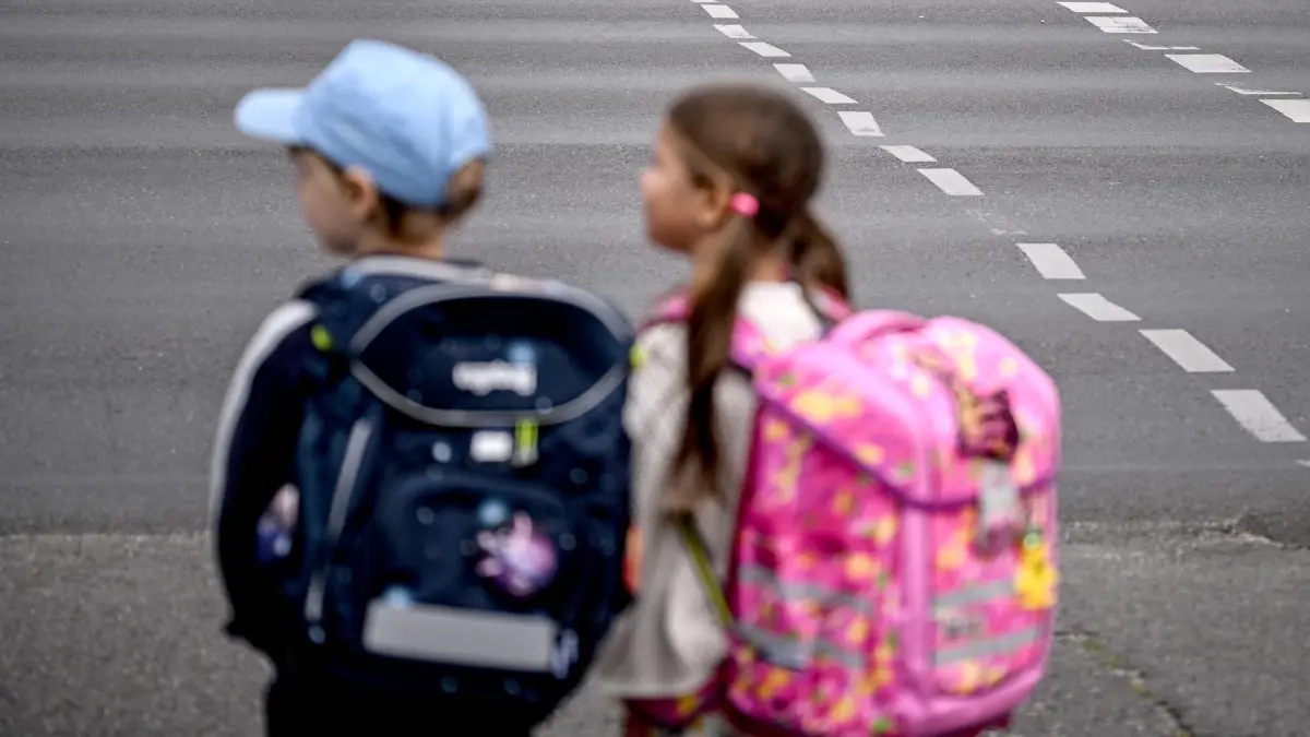 Erster Schultag in Berlin und Brandenburg: 24.08.2026, Berlin: Die Schulanfänger Edgar (6) und Angelina (5) stehen an einer Straße am Rande der Schulanfangskampagne „Achtung Schulweg! Sicher starten, sicher ankommen“. Die Kampagne macht auf die besondere Situation von Kindern im Straßenverkehr aufmerksam und wirbt für mehr Rücksicht und Aufmerksamkeit. Foto: Britta Pedersen/dpa +++ dpa-Bildfunk +++