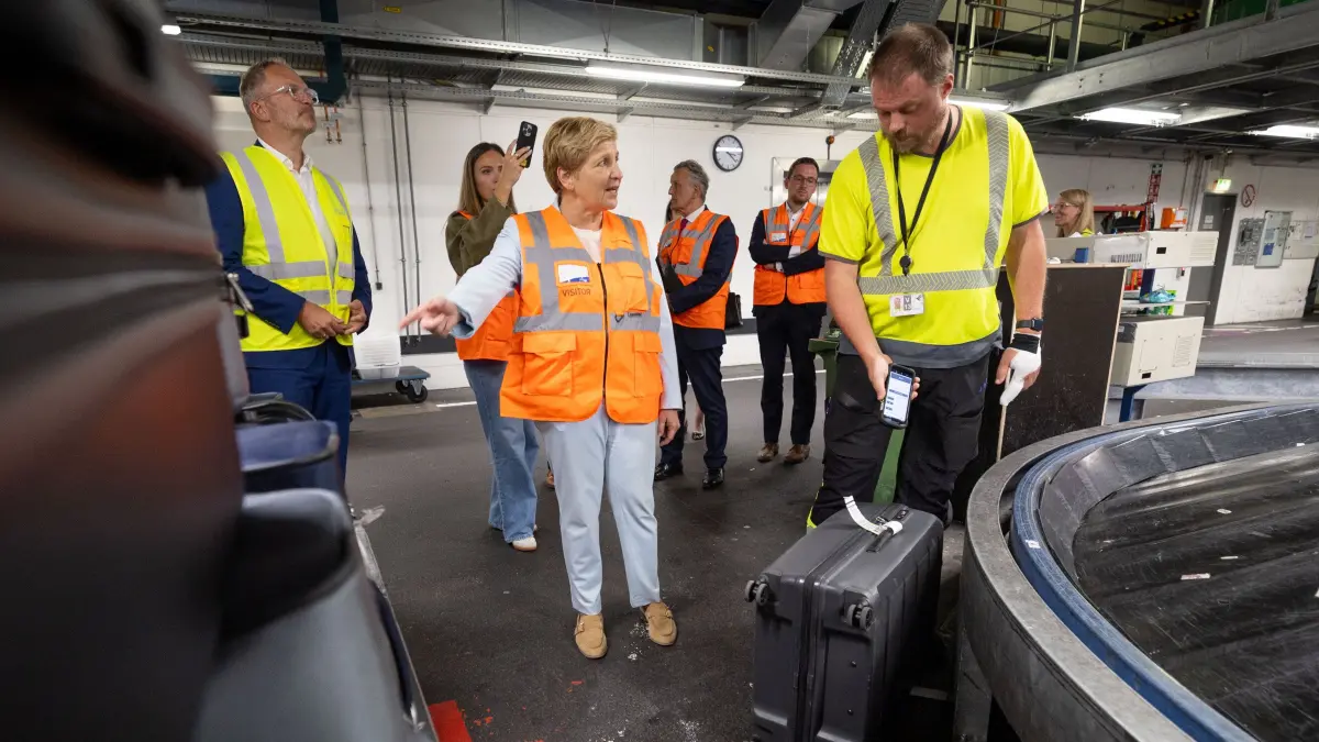 Verkehrsministerin Razavi am Flughafen: Stuttgart, Baden-Württemberg, 24.08.2026:
Nicole Razavi (CDU, Ministerin für Verkehr des Landes Baden-Württemberg) besucht im Rahmen ihrer Sommertour den Flughafen Stuttgart.
Im Bild: Nicole Razavi (CDU, Ministerin für Verkehr des Landes Baden-Württemberg) im Gespräch mit einem Mitarbeiter in der Gepäcksortierung / im Gepäckverteiler. Ganz links: Carsten Poralla (Geschäftsführer der Flughafengesellschaft Stuttgart)
Notiz: No model release. Kein Einverständnis für Werbung, keine Weitergabe an Dritte.