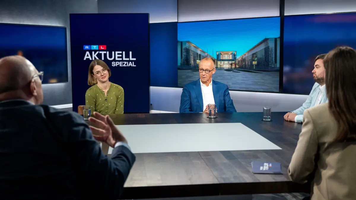 RTL-Interview mit Bundeskanzler Merz: 27.08.2026, Berlin: Bundeskanzler Friedrich Merz (CDU, M) hört nach der RTL-Sendung «Am Tisch mit Friedrich Merz» Studiogast Matthias Kappis (l) zu. In dem Format stellt sich der Bundeskanzler den Fragen von Bürgerinnen und Bürgern im Studio. Foto: Sebastian Christoph Gollnow/dpa +++ dpa-Bildfunk +++
