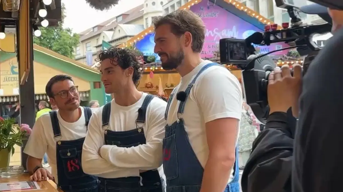 SAT.1-Moderator Christian Wackert (re.) bei den Brüdern Jehle auf dem Stuttgarter Weindorf. Er half wie sie in blauen Latzhosen aus und kellnerte.