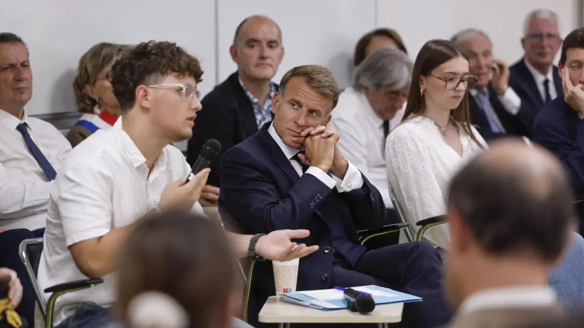 FRANCE-POLITICS-GOVERNMENT-EDUCATION: France's President Emmanuel Macron (C) speaks with with students during a visit to the INSPE University on the first day of the new academic year in Mende, southern France on September 1, 2026. Some 11.6 million primary, middle and secondary school pupils are returning to school on September 1, 2026, with headteachers' preparations having been disrupted by the fallout from a cyberattack targeting the French Ministry of Education this summer. Among the main changes this year are a ban on mobile phones in sixth-form colleges and the distribution to all pupils, from the final year of nursery school to the final year of sixth form, of a questionnaire on gender-based and sexual violence. (Photo by Guillaume HORCAJUELO / POOL / AFP)