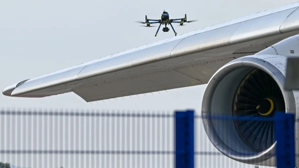 Eine Drohne der Polizei ist am 5. August 2026 über einer Flugzeugtragfläche auf dem Leipziger Flughafen zu sehen.