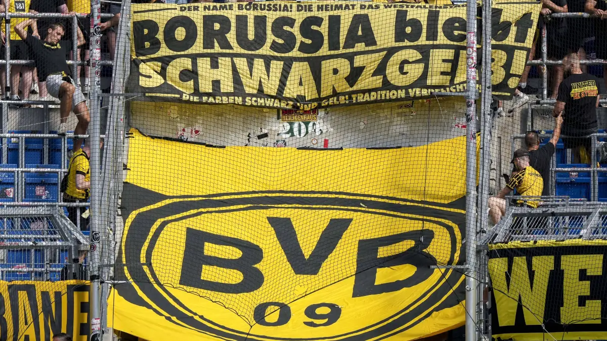 Fussball, Bundesliga, TSG 1899 Hoffenheim - Borussia Dortmund: Die Fans von Borussia Dortmund BVB 09 zeigen in der Fankurve ein Banner, Spruchband mit der Aufschrift: Borussia bleibt Schwarzgelb, darunter das Vereinslogo, Logo vom Verein, Fans, Ultras Publikum, Zuschauer, Stimmung, Atmosphäre, Stadion, 05.09.2026, Sinsheim Deutschland, Fussball, Bundesliga, TSG 1899 Hoffenheim - Borussia Dortmund, DFB/DFL REGULATIONS PROHIBIT ANY USE OF PHOTOGRAPHS AS IMAGE SEQUENCES AND/OR QUASI-VIDEO. *** Borussia Dortmund BVB 09 fans display a banner in the fan section with the slogan Borussia Stays Black and Yellow, featuring the club logo below it fans, ultras, crowd, spectators, atmosphere, stadium, September 5, 2026, Sinsheim, Germany, soccer, Bundesliga, TSG 1899 Hoffenheim vs. Borussia Dortmund DFB and DFL regulations prohibit any use of photographs as image sequences and/or quasi-video xozx