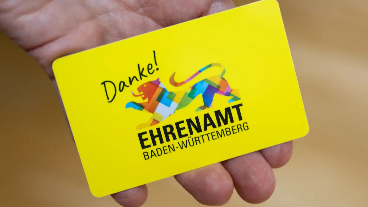 ARCHIV - 26.06.2024, Baden-Württemberg, Stuttgart: Eine Mitarbeiterin des Sozialministeriums Baden-Württemberg zeigt vor einer Pressekonferenz im Sozialministerium Baden-Württemberg eine Ehrenamtskarte. (zu dpa: «Land will Ehrenamtskarte 2025 flächendeckend einführen») Foto: Marijan Murat/dpa +++ dpa-Bildfunk +++