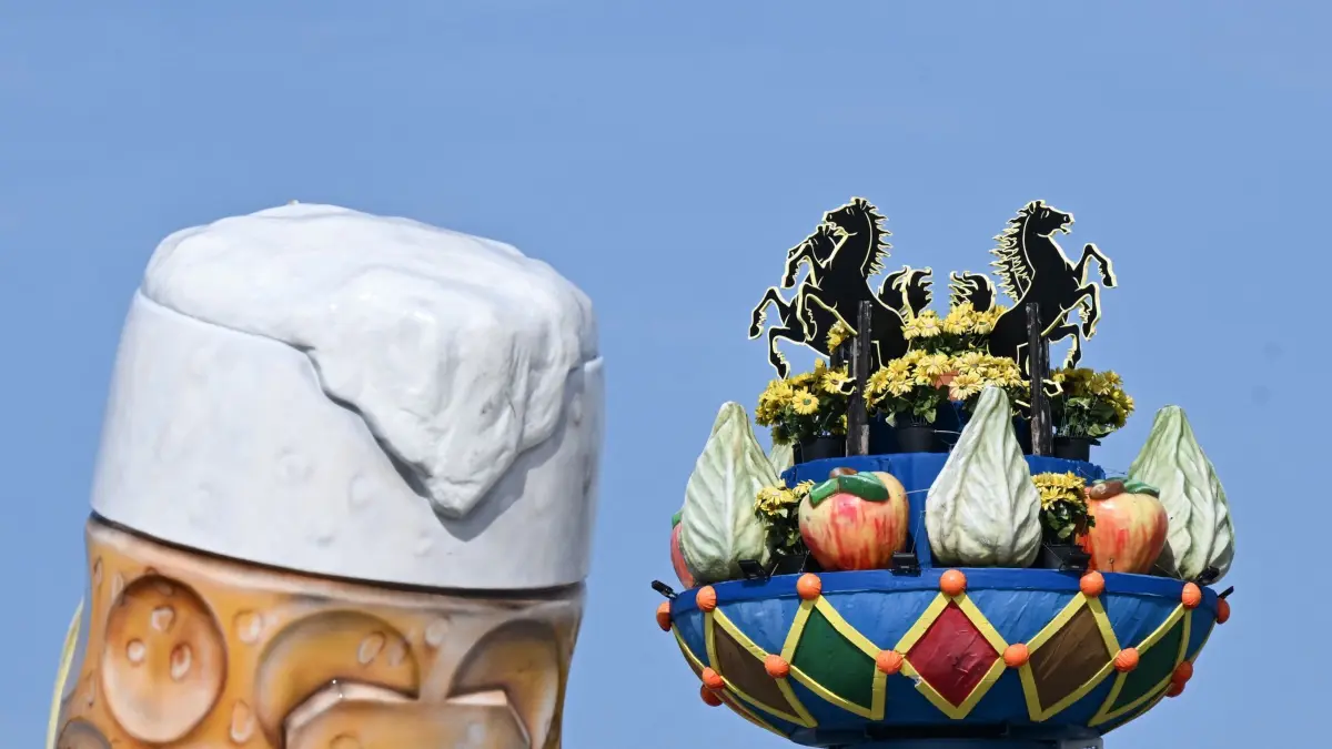 Vor dem 179. Cannstatter Volksfest: PRODUKTION - 11.09.2026, Baden-Württemberg, Stuttgart: Die neue Fruchtsäule steht auf dem Festgelände Cannstatter Wasen neben einem überdimensionalen Modell eines Bierkrugs. Die Fruchtsäule ist ein Wahrzeichen des Festes, sie soll an die Ursprünge des Fests im 19. Jahrhundert erinnern. Foto: Bernd Weißbrod/dpa +++ dpa-Bildfunk +++