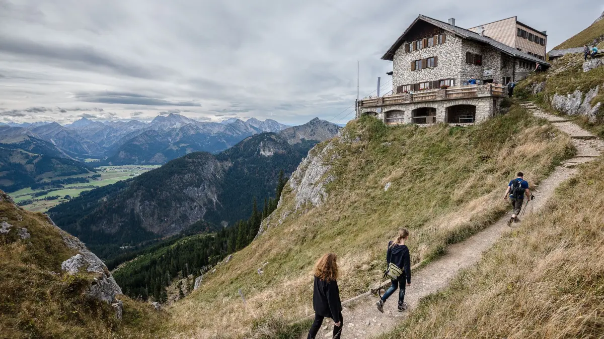 Wanderer gehen zur Bad Kissinger Hütte: Nicht nur Schutzort, sondern auch Informationsquelle: Hüttenwirte wissen meist sehr genau, wie es um die umliegenden Routen bestellt ist. (zu dpa: «Alpen im Wandel: Wie Bergfreunde mit neuen Risiken umgehen»)