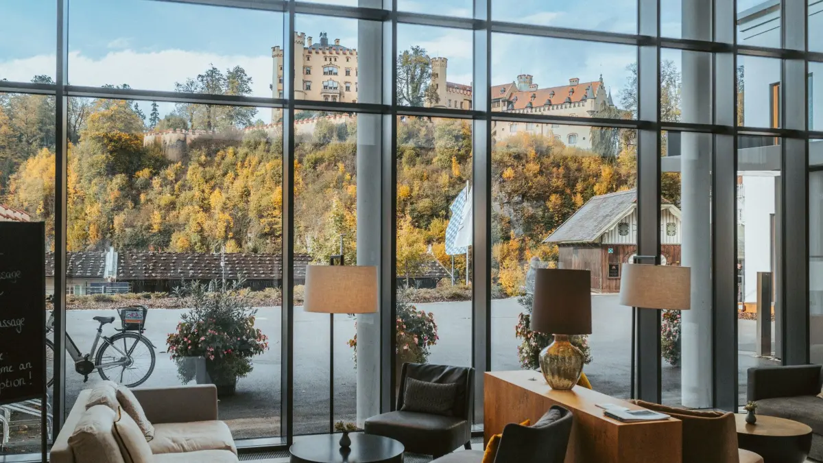 Die Lobby heißt Gäste willkommen, während Schloss Hohenschwangau durch die Fenster zum Blickfang wird.