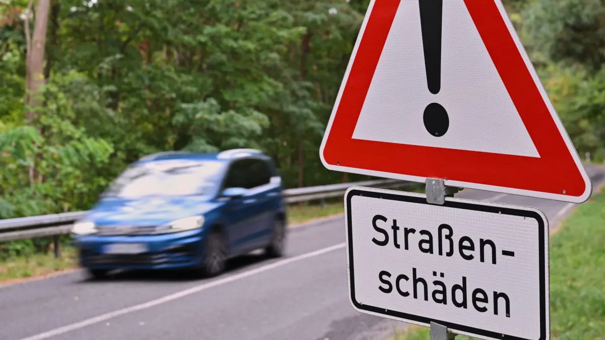 Erhaltungsprogramm für Landesstraßen in Brandenburg: 21.09.2026, Brandenburg, Kehrigk: Eine Gefahrenschild "Straßenschäden"steht an einer Landstraße. Am selben Tag fand die Auftaktveranstaltung des Erhaltungsprogramms für Landesstraßen in Brandenburg statt. Ziel des Programms ist die Sanierung besonders stark geschädigter Landesstraßen. Bis 2031 sollen bis zu 520 Kilometer Landesstraßen erneuert werden. Die erste Maßnahme betrifft die L 74 bei Kehrigk. Die Bauarbeiten beginnen am 28. September. Foto: Patrick Pleul/dpa +++ dpa-Bildfunk +++