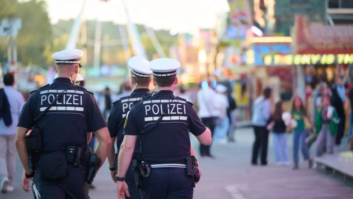 Auftakt Cannstatter Volksfest: 25.09.2026, Baden-Württemberg, Stuttgart: Polizisten gehen zwischen Buden und Fahrgeschäften des Cannstatter Volksfestes. Das zweitgrößte Volksfest der Welt findet auf dem Festgelände auf dem Cannstatter Wasen bis zum 11. Oktober statt. Foto: Marijan Murat/dpa +++ dpa-Bildfunk +++
