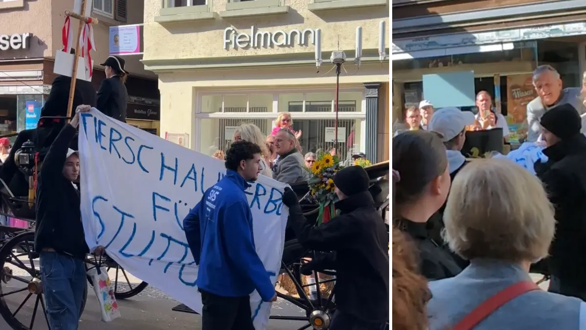 Tierschutz-Aktivisten halten beim Cannstatter Volksfestumzug ein Banner. Kurz darauf greift Oberbürgermeister Frank Nopper vom Wagen aus zu und greift danach.
