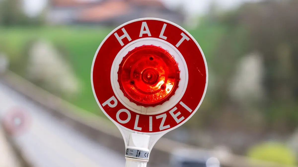 Polizei Verkehrskontrolle: ARCHIV - 09.04.2024, Bayern, Viechtach: Eine Kelle mit der Aufschrift «Halt Polizei» wird während einer Verkehrskontrolle hochgehalten. (zu dpa: «Ermittlungen nach illegaler Einfuhr von Feuerwerkskörpern») Foto: Armin Weigel/dpa +++ dpa-Bildfunk +++
