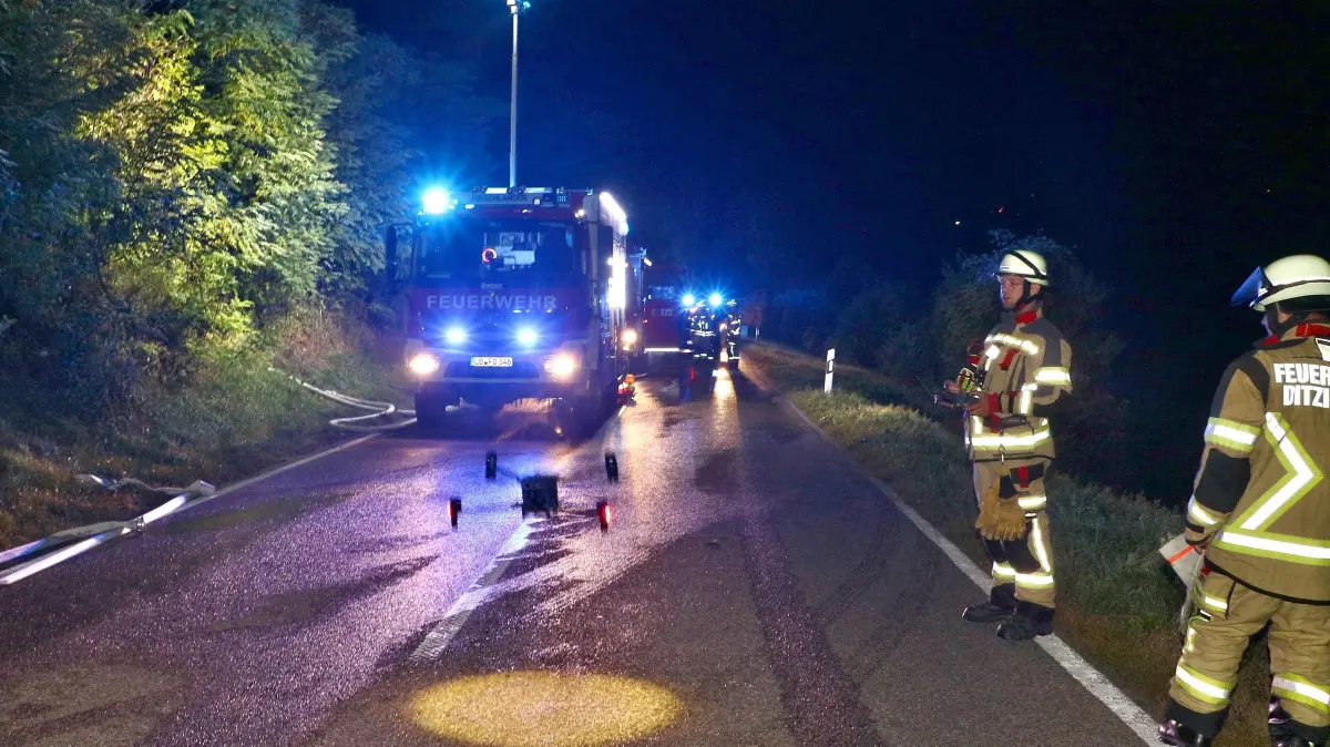 04.10.2026: Ein Brand auf einem Gartengrundstück an der Landesstraße L1136 zwischen Schöckingen und Hemmingen beschäftigte in der Nacht auf Sonntag insgesamt drei Feuerwehren über mehrere Stunden. Gegen 01:26 Uhr alarmierte die Integrierte Leitstelle Ludwigsburg die Abteilungen Hirschlanden und Schöckingen der Freiwilligen Feuerwehr Ditzingen mit dem Alarmstichwort "B2 - Feuer/Rauch unklare Lage Freiland auf die L1136 in Richtung Hemmingen. Die ersten Kräfte fanden beim Eintreffen zwei aneinandergebaute Gartenhäuser vor, die im Vollbrand standen. Die Zugang war nur über einen schmalen Hohlweg möglich, zudem befand sich das Grundstück an einem Hang. Auf Grund dieser Lage, insbesondere der nicht vorhandenen Wasserversorgung vor Ort, forderte der Einsatzleiter zwei weitere Hilfeleistungslöschfahrzeuge der Abteilung Ditzingen-Kernstadt nach. Mit insgesamt vier Rohren wurde eine umfassender Löschangriff eingeleitet und die Einsatzstelle großräumig ausgeleuchtet. Mit den Tanks der Löschfahrzeuge wurde im Pendelverkehr Löschwasser an die Brandstelle transportiert. Um den Bedarf an Pressluftatmern und Geräteträgern zu decken, wurde der Abrollbehälter-Atemschutz der Freiwilligen Feuerwehr Leonberg und ein weiteres Löschfahrzeug der Freiwilligen Feuerwehr Hemmingen nachgefordert. Um versteckte Glutnester in dem schwer zugänglichen Brandobjekt besser lokalisieren zu können, kam auch die Drohne der Feuerwehr Ditzingen zum Einsatz. Die Nachlösch- und Aufräumarbeiten zogen sich bis in die frühen Morgenstunden hin. Die Landesstraße zwischen Schöckingen und Hemmingen musste während der Einstzmaßnahmen voll gesperrt werden. Foto: KS-Images.de/Andreas Rometsch